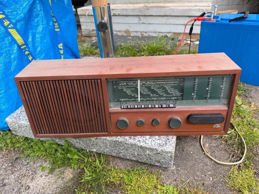 Äldre radioapparat i träskåp med grön kanalskala och svarta reglage